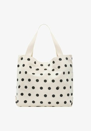 Biała torba na ramię wykonana z materiału typu płótno z dużymi czarnymi groszkami i dwoma szerokimi paskami na ramiona na jednolitym tle.