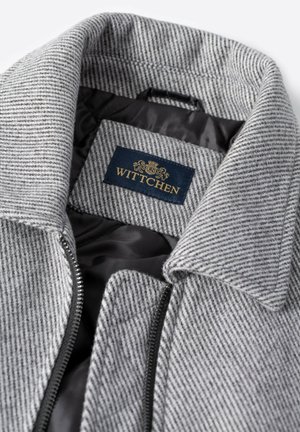 Grauer gestreifter Mantel mit Reverskragen, Reißverschluss und schwarzer Innenfütterung. Verfügt über ein innen eingenähtes WITTCHEN-Label.