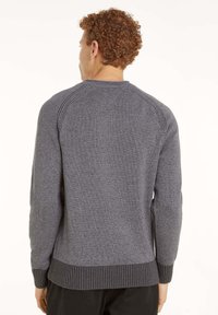 Grauer Strickpullover mit gerippten Bündchen und Saum. Verfügt über einen Rundhalsausschnitt und Raglanärmel. Das Material hat eine weiche Textur und ein dezentes Muster.