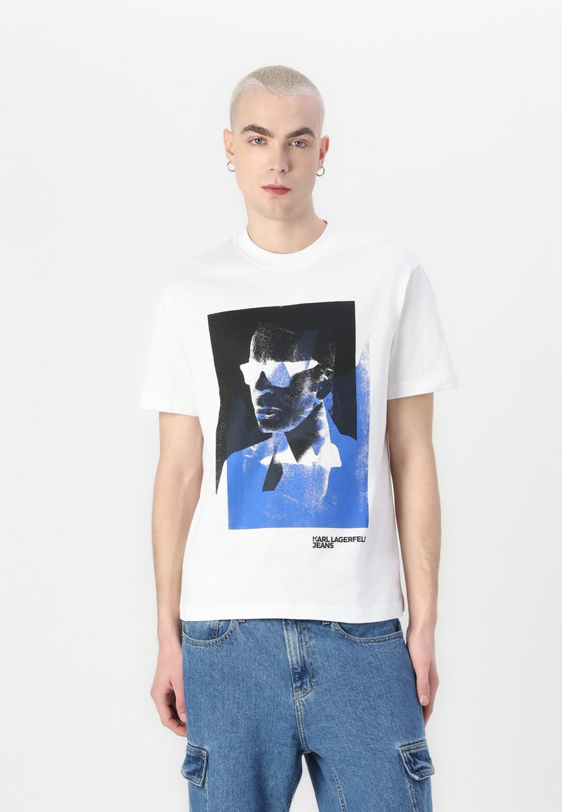 Bijela pamučna majica s grafičkim printom u crnoj i plavoj boji, prikazuje stilizirano lice, s natpisom "KARL LAGERFELD JEANS".
