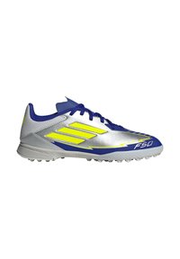 Silver athletic shoe with blue and yellow accents, featuring a sleek design, textured upper, and a studded grey outsole. Model F50.