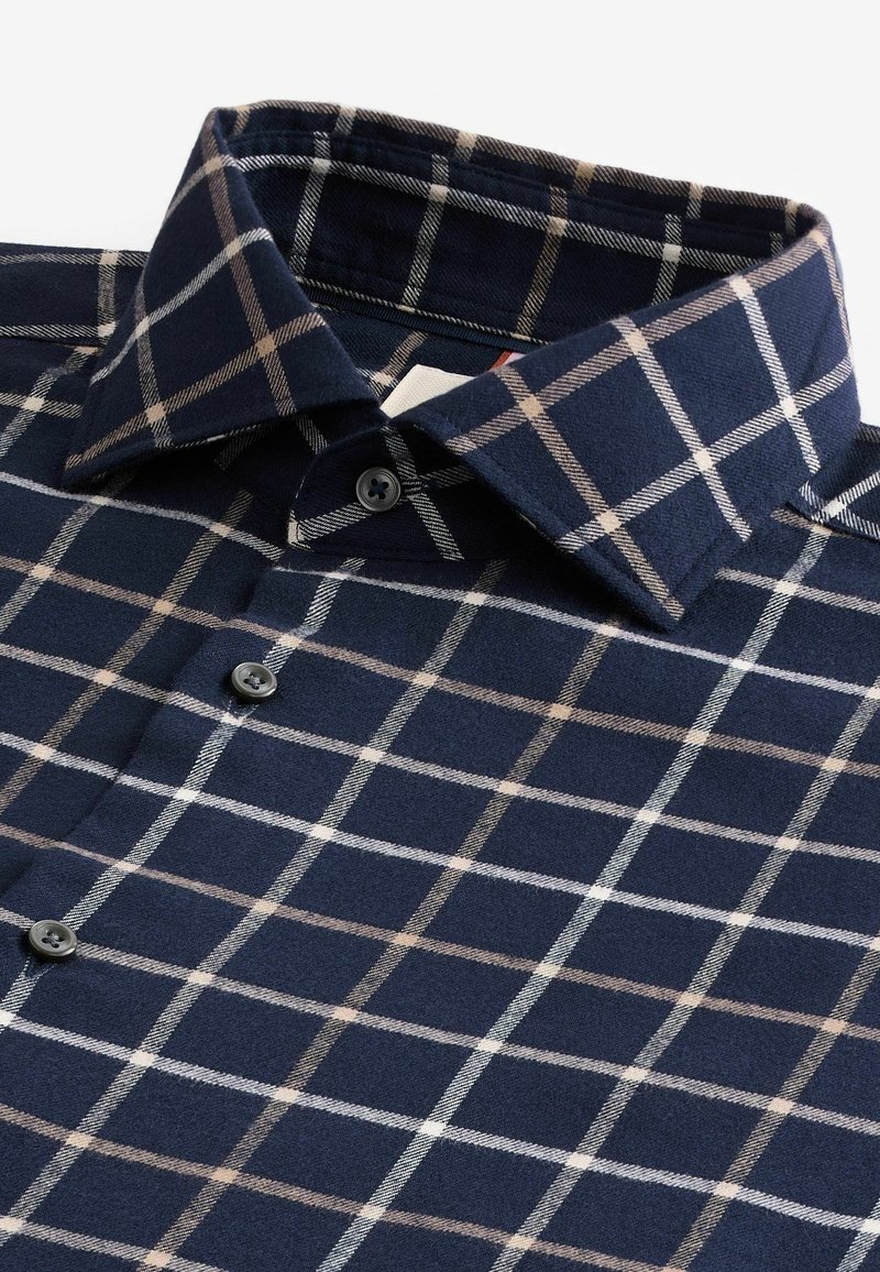 Chemise bleu marine avec motif à carreaux blanc et beige, boutons sur le devant et col large.