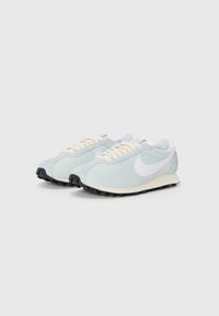 Lysblå løbesko med hvid Nike-swoosh, struktureret overdel, cremefarvede snørebånd og sort gummiydersål med synlige grebsstænger.