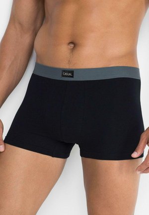 Boxer di cotone neri con una fascia in vita grigia recante la scritta "CASUAL" su un'etichetta. Il design è semplice con un taglio aderente.