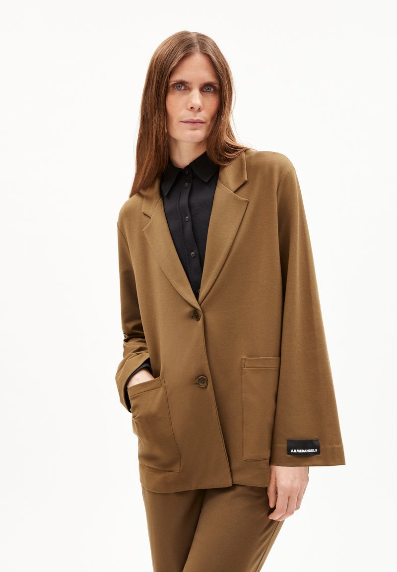 Brauner Blazer mit lockerer Passform, aus weichem Stoff. Verfügt über eine Ein-Knopf-Verschluss, große Taschen und ein Etikett am Ärmel.