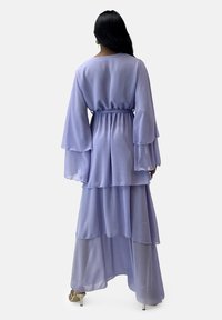 Vestito in chiffon color lavanda con design a strati e maniche a campana, con vita elastica e gonna fluida e trasparente. Orlo asimmetrico.