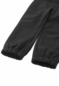 Czarne spodnie sportowe wykonane z gładkiego materiału, z elastycznymi mankietami przy kostkach i zwężającym się krojem. Minimalistyczny i funkcjonalny styl.