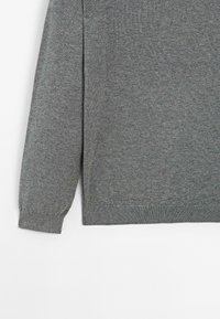 Maglione grigio chiaro lavorato a maglia con maniche lunghe, scollatura rotonda, polsini a coste e una texture sottile. L'orlo ha una vestibilità leggermente loose.