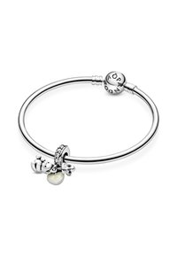 Pulsera de charms de plata que presenta una banda lisa, dos charms de oso, una cuenta con acento de cristal y un charm de corazón con un acabado perlado.