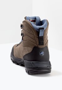 Stivale da trekking marrone con upper testurizzato, suola in gomma nera e collo imbottito blu. Presenta occhielli per i lacci e dettaglio del logo sul tallone.