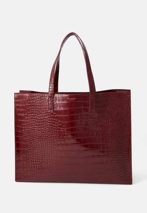 Sac fourre-tout bordeaux avec motif crocodile et finition brillante, doté de deux poignées robustes et sans accents en métal. Forme carrée.