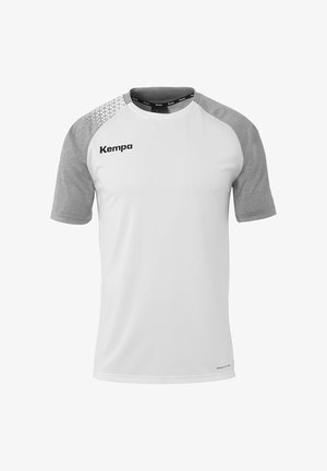 Witte sportshirt met grijze raglanmouwen. Heeft een geometrisch patroon op de schouder en het "Kempa"-logo op de voorkant. Soepele textuur.
