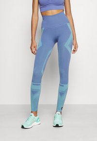 Tights i en gradient av blått och teal med geometriska mönster, hög midja design och elastiskt tyg för komfort och rörlighet.