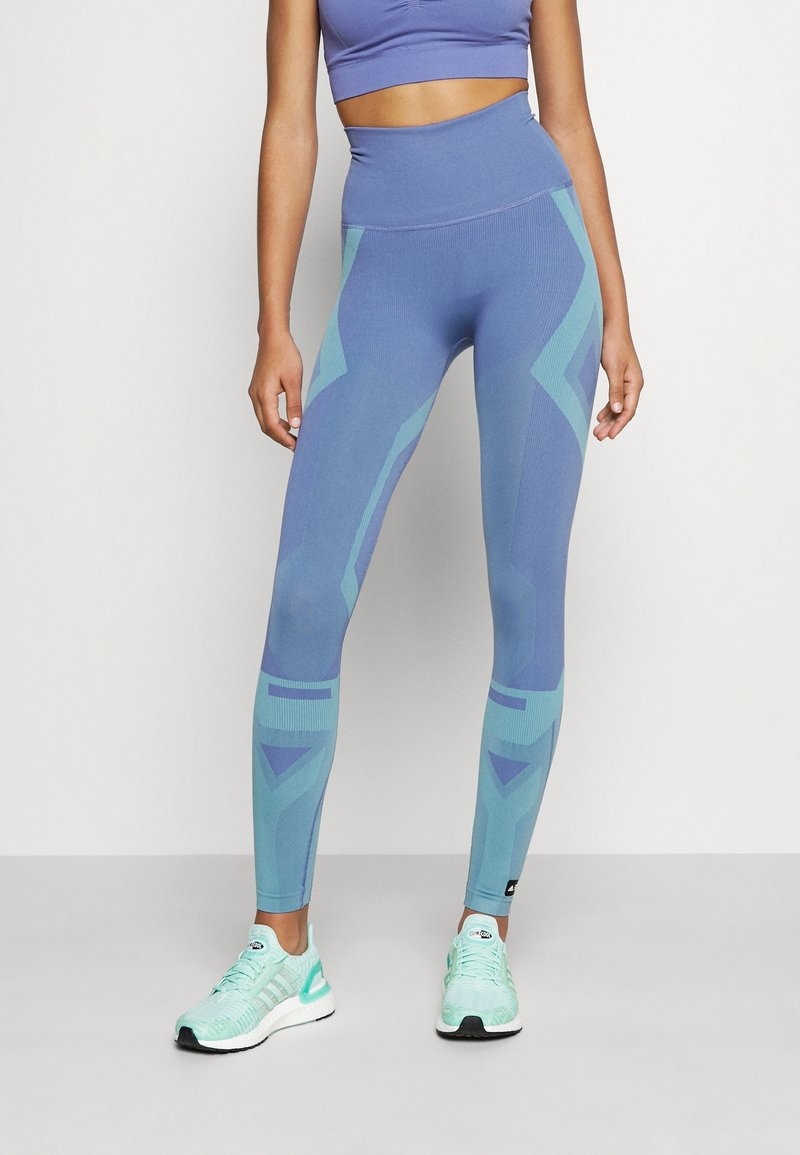 Tights i en gradient av blått och teal med geometriska mönster, hög midja design och elastiskt tyg för komfort och rörlighet.