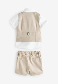Bež prsluk za malu djecu s podesivom kopčom na leđima, bijela košulja kratkih rukava s ovratnikom i bež kratke hlače s elastičnim strukom, položeni ravno.