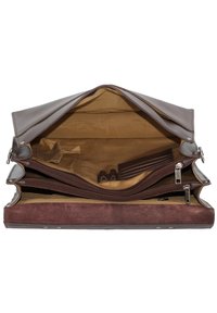 Bruine leren tas met meerdere compartimenten, gladde buitenkant, gestructureerde suède onderkant en met rits gesloten zakken. Gecoat met een lichter stof.