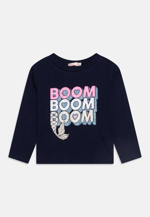 Maglietta a maniche lunghe blu navy con la scritta "BOOM BOOM BOOM" in lettere multicolori e una grafica di una coda di sirena argentata e scintillante in basso a sinistra.