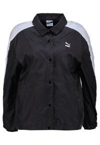 Giacca nera in nylon con colletto, dettagli bianchi sulle spalle, bottoni a scatto e un piccolo logo Puma sul lato sinistro del petto.