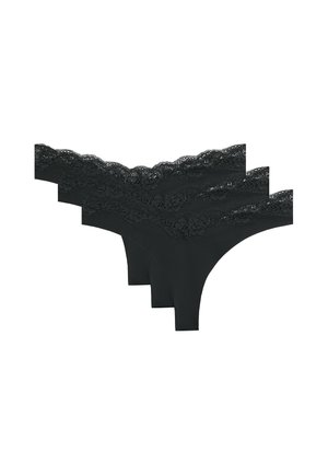 Trois strings noirs pour femmes ornés de dentelle, superposés sur un fond blanc.