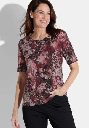 Haut à manches courtes présentant un motif paisley bordeaux et noir. Fabriqué dans un tissu léger et lisse, avec un col rond et une coupe décontractée.