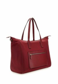 Sac fourre-tout en nylon rouge avec des accents en cuir, forme rectangulaire, deux poignées pour l'épaule et une poche avant zippée. Texture lisse.