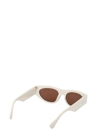 Valkoiset kissansilmälasit ruskeilla linsseillä, joissa on tekstuuroitu runko ja kultainen yksityiskohta sarvessa. Silkkiset reunat ja virtaviivaiset varyt.