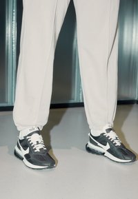 Svarta och vita Nike-sneakers i mesh och mocka, med en dämpad sula, vita snören och logotypdetaljer på tungan.