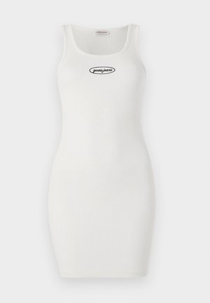 Valkoinen ribattu bodycon-mekko, jossa on pyöreä pääntie ja ohuet hihnat, edessä musta brodeerattu "guess.jeans" -logo.