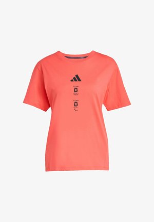 Lososově korálové tričko s krátkými rukávy z bavlny, s kulatým výstřihem a černým logem Adidas a nápisem "TEAM D" se symboly olympijských a paralympijských her.