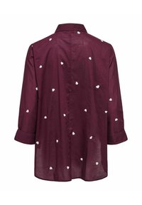 Burgundi broderdat särk krae, millel on valged südame mustrid, pikad varrukad, mis on mansetidelt üles keeratud ning lõdva lõikega.