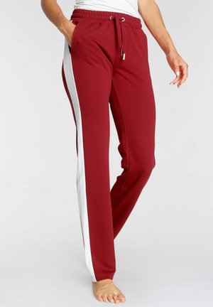 Maroon sweatpants with white side stripes, elastic waistband with drawstring, and a soft textured fabric. Designed for comfort and mobility.
