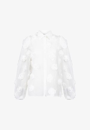 Witte shirt met een knoopsluiting, textuurstof en driedimensionale rozenapplicaties verspreid over het oppervlak.