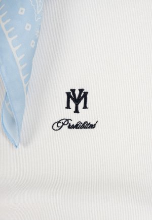 Valge sooniline kangas musta tikandiga NY monogrammiga kursiivkirjas teksti "Prohibited" kohal ning vasakul osaliselt nähtav heleroheline mustriline kangas.