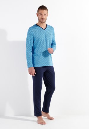 Long-sleeve blue patterned shirt with navy v-neck collar and matching navy pants, made from soft fabric, featuring a relaxed fit.