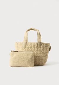 Beige quiltet tote bag med dobbelte håndtag og glatte detaljer, suppleret med en lille matchende lynlås pung. Begge har en blød tekstur.