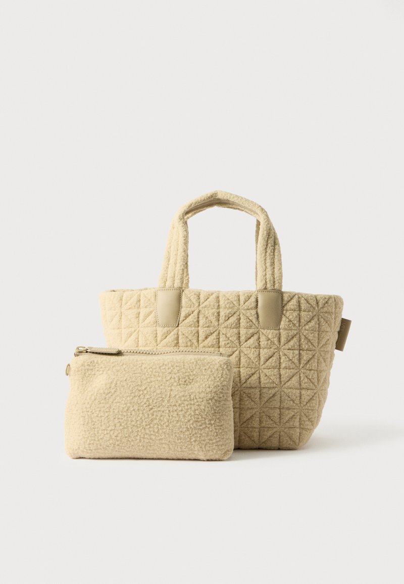 Sac fourre-tout beige matelassé avec deux poignées et des accents lisses, accompagné d'une petite pochette zippée assortie. Les deux présentent une texture douce.
