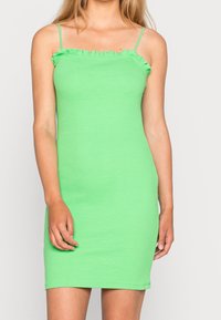 Zielona sukienka z prążkowanego materiału z cienkimi ramiączkami, z falbanką przy dekolcie i dopasowanym krojem, prezentująca gładką powierzchnię.