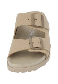 Beige suede slide sandal with two adjustable straps and buckles. Features a contoured footbed and textured rubber sole for grip.