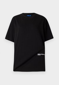 Svart bomull T-skjorte med rund hals, korte ermer og en hvit "KARL LAGERFELD JEANS" logo nederst til venstre.