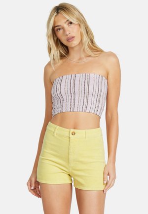 Top court sans bretelles avec un motif rayé lilas et blanc, associé à un short en velours côtelé jaune taille haute avec une fermeture à bouton.