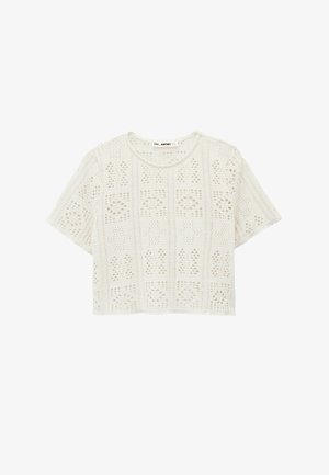 Wit kort mouwtjes crochet gebreid cropped topje met een geometrisch opengewerkt patroon en een ronde halslijn.