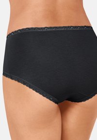 Culotte noire taille haute en tissu doux, présentant une bordure en dentelle festonnée à la taille et aux ouvertures des jambes. Texture lisse, sans motifs visibles.