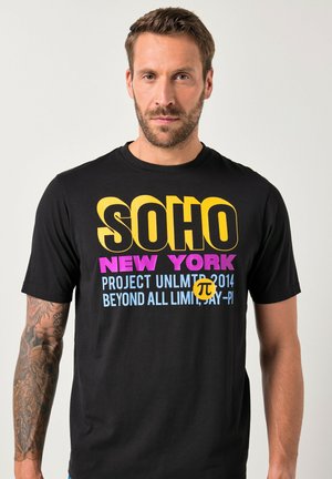 Sort bomulds T-shirt med dristig, flerfarvet tekst: "SOHO NEW YORK" i gul og pink, samt yderligere tekst i blå.
