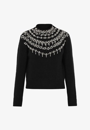 Černý svetr s vysokým límcem, zdobený bílými květinovými korálky v vrstvených vzorech přes hrudník a ramena.