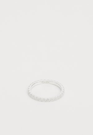 Bague en argent avec une bande délicate et ornée, mettant en valeur de petites pierres précieuses transparentes disposées en une ligne continue tout autour de la circonférence.