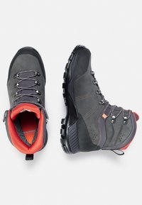 Bottines de randonnée grises avec des semelles en caoutchouc noir, dotées d'œillets en métal, d'accents orange et d'un col rembourré rouge pour le confort.