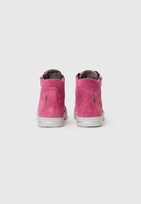 Pink suede ankle boots with gray rubber soles, side zippers, and a soft interior lining. Features a logo on the back.