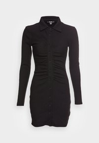 Svart långärmad klänning i ribbat material, med knapplist fram och samlade detaljer längs midjan. Enkel kragsdesign.