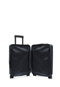 Valise rigide bleu marine avec une poignée télescopique, quatre roues et un intérieur en tissu texturé ; elle dispose d'un compartiment zippé et de séparateurs.