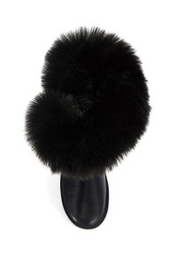Bota negra con una base de cuero suave y un amplio puño de pelaje sintético en la parte superior. El pelaje es esponjoso y denso, creando una silueta redondeada.
